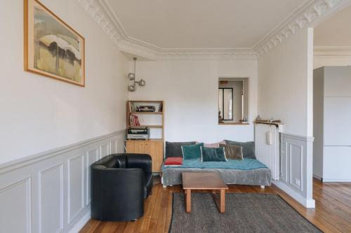 パリにあるLuminous Parisian-style 1BD ApartmentBellevilleのリビングルーム(ソファ、椅子付)