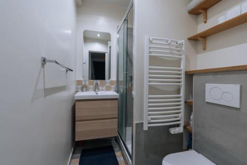 パリにあるLuminous Parisian-style 1BD ApartmentBellevilleのバスルーム(シャワー、トイレ、シンク付)