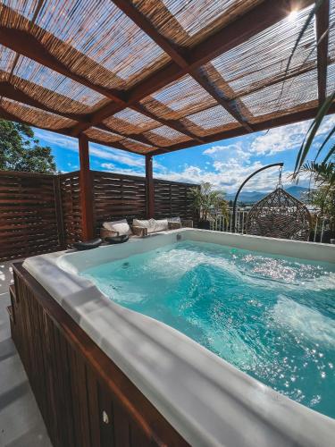a hot tub on a patio with a pergola at Villa Verde Bangalô - Garopaba - SC in Garopaba