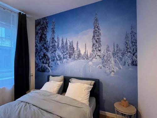 Suite Cosy MontBlanc en Hyper Centre في فالنسيان: غرفة نوم مع لوحة جدارية لغابة مغطاة بالثلوج
