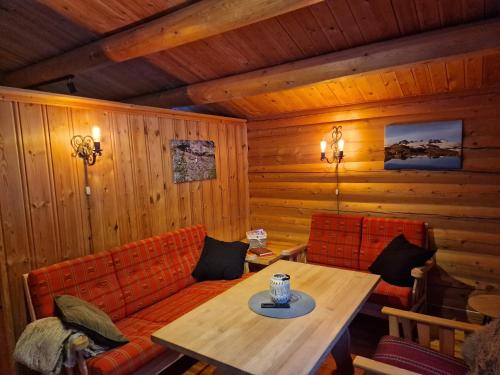 una habitación con sofá y mesa en una cabaña en Weistad, en Heidal