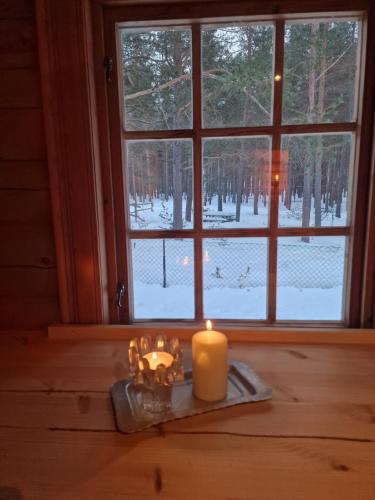 a candle sitting on a table in front of a window at Weistad in Heidal