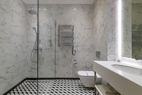 a bathroom with a shower and a toilet and a sink at Modern Art Hotel in Lviv