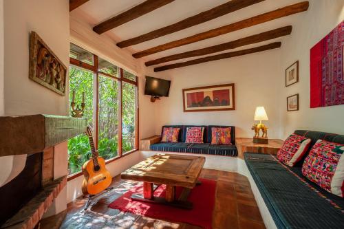 sala de estar con sofá y guitarra en Casa de Las Aguas, en Villa de Leyva