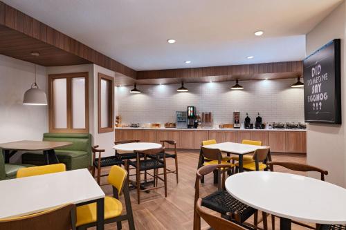 a restaurant with tables and chairs and a counter at Fairfield by Marriott Inn & Suites Hillsboro in Hillsboro