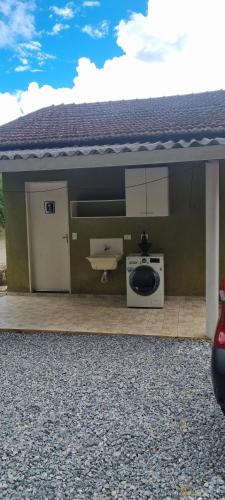 a bathroom with a sink and a washing machine at Lírios da Montanha in Santo Antônio do Pinhal