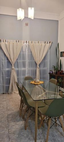 una sala da pranzo con tavolo in vetro e sedie di Finchu a Barrio Esteban Echeverría