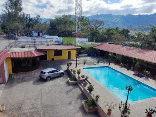 un coche aparcado frente a un edificio con piscina en hotel ivon, en Esquipulas