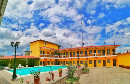 un gran edificio amarillo con piscina en hotel ivon, en Esquipulas
