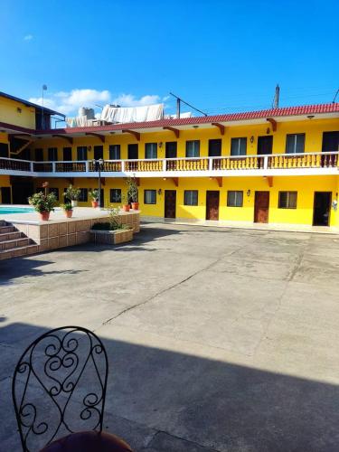 ein gelbes Gebäude mit einem Stuhl davor in der Unterkunft hotel ivon in Esquipulas