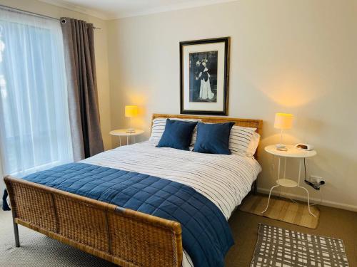 a bedroom with a large bed with blue pillows at Clampetts Pet Friendly Close to Township in Robe