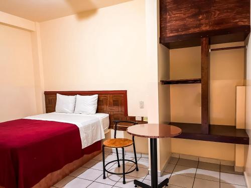 a hotel room with a bed and a table at Hotel Buenos Aires in Durango