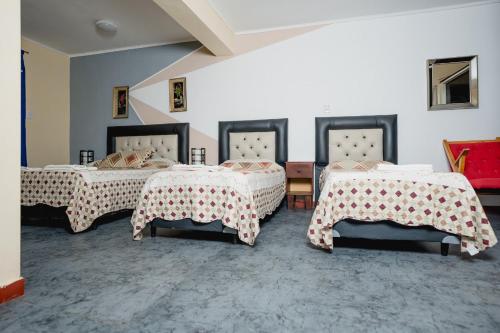 a room with two beds with curtains on them at Hotel Alojamiento Raque-Lito in Patquía