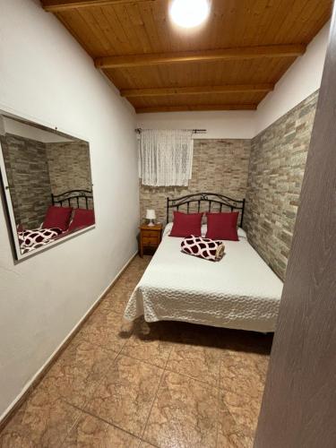 a bedroom with a bed and a brick wall at Chalet Rutas de Valsequillo in Valsequillo