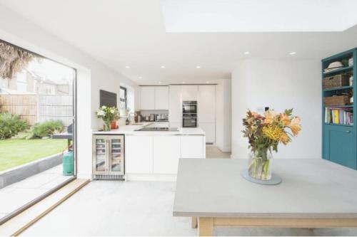 a kitchen with a vase of flowers on a table at Striking & Modern 2BD Flat wGarden - East Dulwich in London