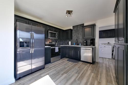 a kitchen with black cabinets and stainless steel appliances at Little Elm Diamond - Steps to Lewisville Lake! in Little Elm