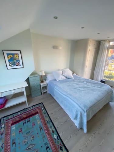 a bedroom with a large bed with a blue blanket at Delightful 2BD Cottage-Chic House Hammersmith! in London