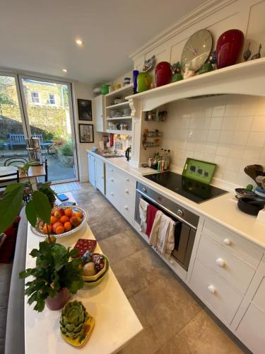 a kitchen with fruits and vegetables on a counter at Delightful 2BD Cottage-Chic House Hammersmith! in London