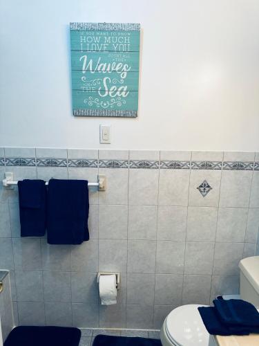 a bathroom with a toilet and a sign on the wall at Pipo’s perfect place in Jersey City