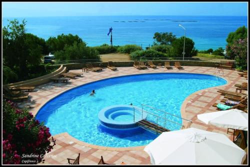ein großer Pool mit Stühlen und das Meer in der Unterkunft Magnifique T2 vue Mer Sanguinaires in Ajaccio