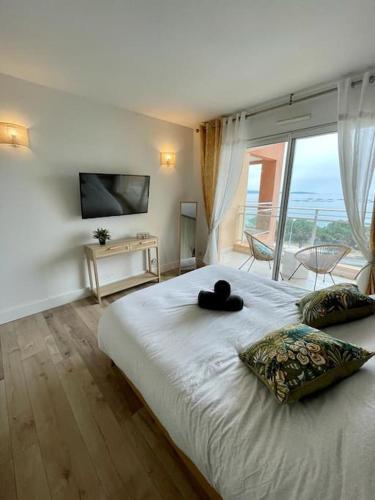 ein Bett mit einem schwarzen Hut drauf in der Unterkunft Magnifique T2 vue Mer Sanguinaires in Ajaccio
