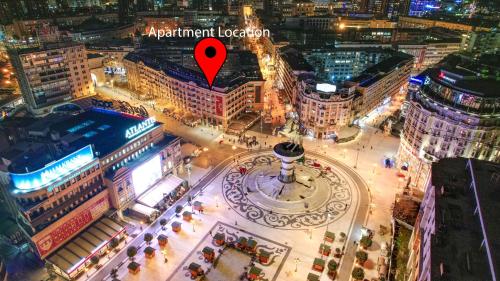 an aerial view of a city at night with a red arrow at Fantazy Apartment Main Square in Skopje