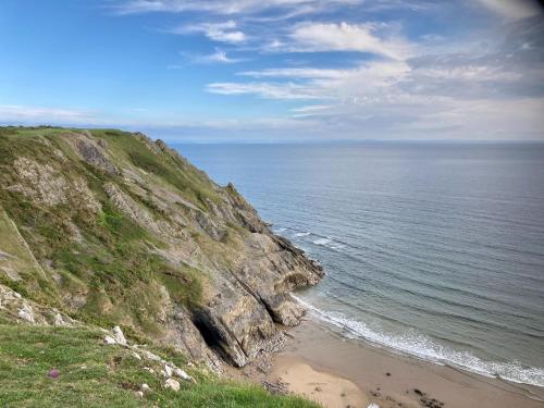 Blick auf das Meer von einer Klippe mit Strand in der Unterkunft Tides Reach Guest House in The Mumbles