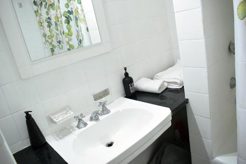 Baño blanco con lavabo y espejo en Florida Garden 624 en Buenos Aires