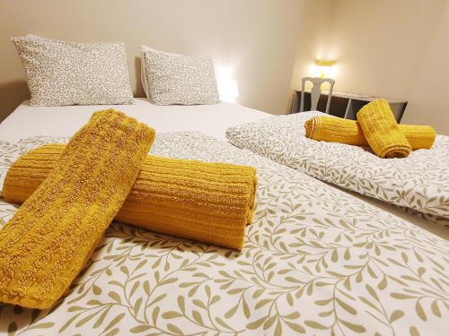 two beds with yellow blankets and pillows on them at Beautiful, convenient, central room 2 in Bergen