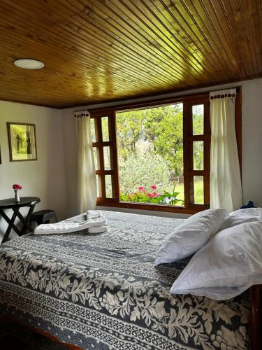ein Schlafzimmer mit einem Bett und einem großen Fenster in der Unterkunft Finca La Toscana in Pereira