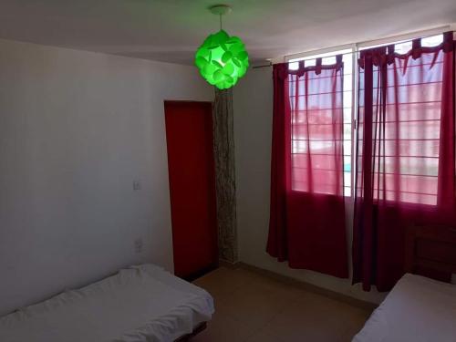 Habitación con 2 camas y luz verde en Departamento de 4 ambientes dos habitaciones dos baños en Mar del Plata