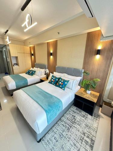 Un dormitorio con dos camas y una mesa. en Manila Bay Retreat at Soleil Suite, en Manila