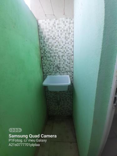 baño con lavabo y pared verde en Apartamento em Muriqui - RJ - Apto. 202, en Mangaratiba
