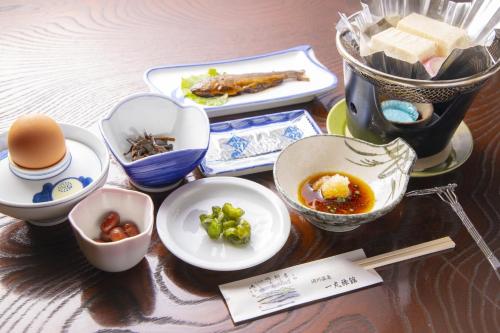Ichimaru Ryokan - Vacation STAY 59257v في Tenkawa: طاولة مليئة بالأطباق وأطباق الطعام