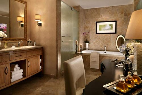 a bathroom with a tub and a sink and a mirror at Trump International Hotel in Las Vegas