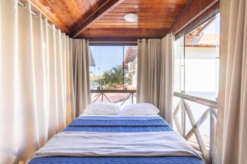 a bed in a room with a large window at Casa Paresí completa na Praia dos Carneiros in Tamandaré