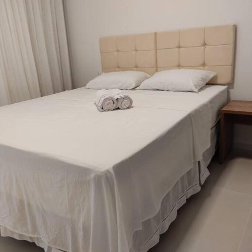 a white bed with two towels on top of it at Lindo apartamento na Barra in Salvador