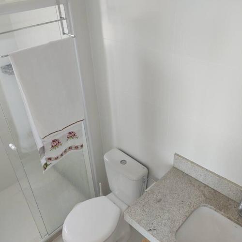a white bathroom with a toilet and a shower at Lindo apartamento na Barra in Salvador