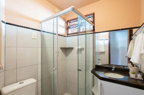 a bathroom with a glass shower and a sink at Casa Paresí completa na Praia dos Carneiros in Tamandaré