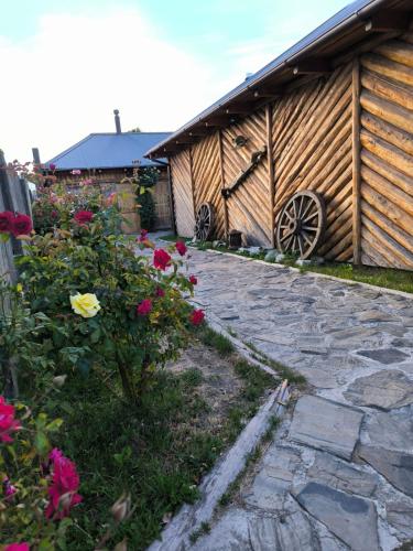 a stone walkway next to a building with flowers at Hotel Último Paraíso in Cochrane