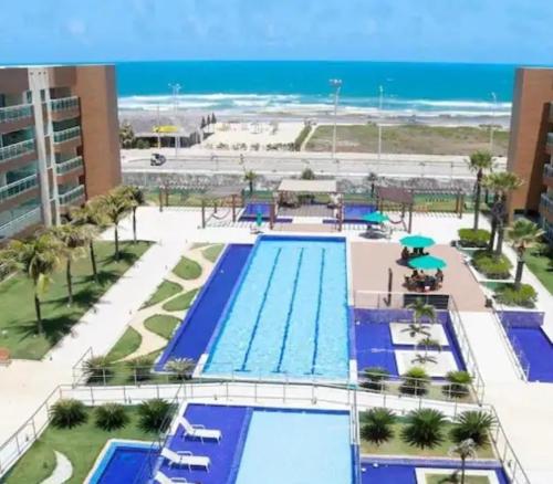 a swimming pool with the ocean in the background at LUGAR INCRÍVEL - VG FUN PRAIA DO FUTUTO FORTALEZA in Fortaleza