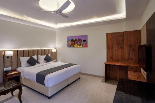 um quarto com uma cama e uma ventoinha de tecto em OYO Collection O Hotel Sg Inn em Greater Noida