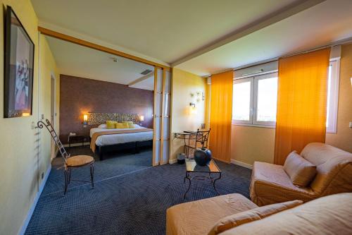 a hotel room with a bed and a living room at Best Western Adagio Saumur in Saumur