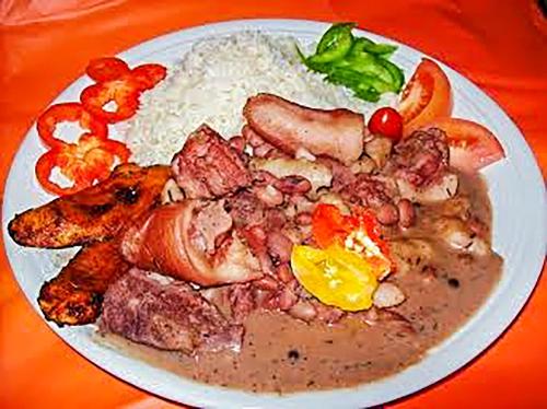 a plate of food with meat and rice on a table at SGR Near The Sea in Bull Bay