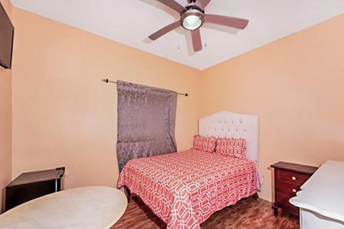 a bedroom with a bed and a ceiling fan at SGR Near The Sea in Bull Bay