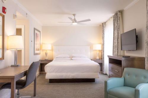 a hotel room with a bed and a desk and a desk at Homewood Suites by Hilton Palm Beach Gardens in Palm Beach Gardens