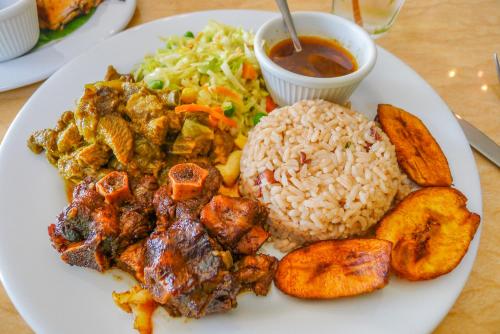 a plate of food with rice and meat and vegetables at SGR Near The Sea in Bull Bay