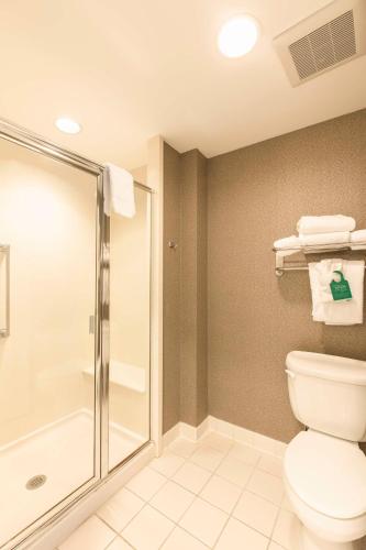 a bathroom with a toilet and a shower at Homewood Suites by Hilton Palm Beach Gardens in Palm Beach Gardens