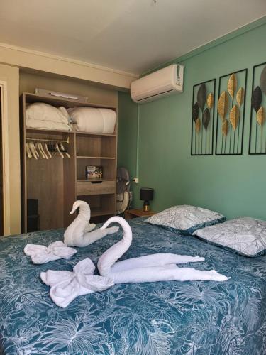 a bed with two swans sitting on top of it at Résidence Belle Anse 4 Pers 3ilets in Les Trois-Îlets