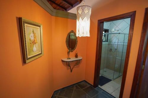 ein Badezimmer mit einem Spiegel, einem Waschbecken und einer Dusche in der Unterkunft Espaço Villa Verde in Socorro